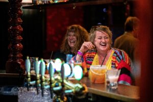 2 kvinder i baren er i godt humør foran baren i rock'en på crazy daisy svendborg